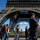 French CRS policemen patrol as tourists walk past in front of the Eiffel Tower in Paris, France August 20, 2016.